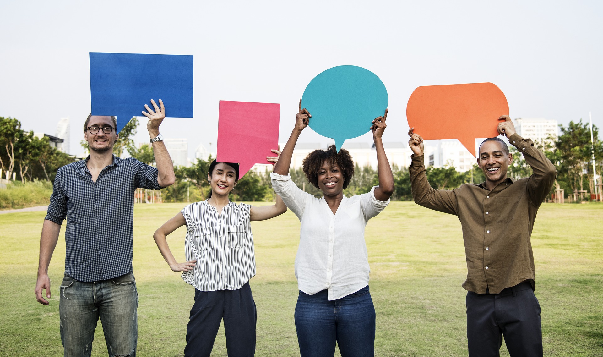 Menschen halten Sprechblasen aus Papier hoch – Symbol für Feedback